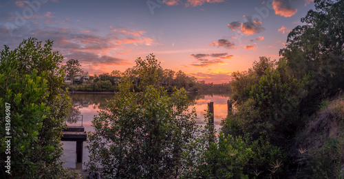 Panoramic Riverside Sunrise with Cloud Reflections