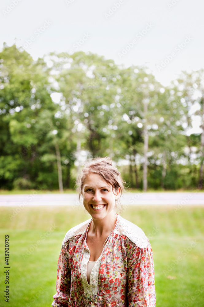 Portrait of happy woman standing on field at park Portrait of happy woman standing on field at park