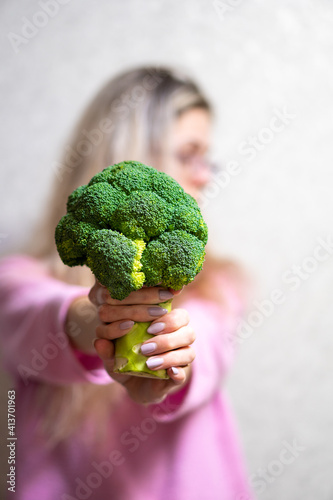 Young girl holding broccoli. Concept healthy life photo