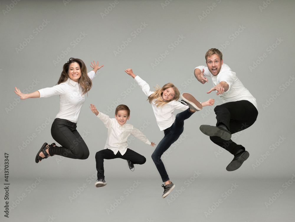Portrait of family jumping against gray background Portrait of family jumping against gray background