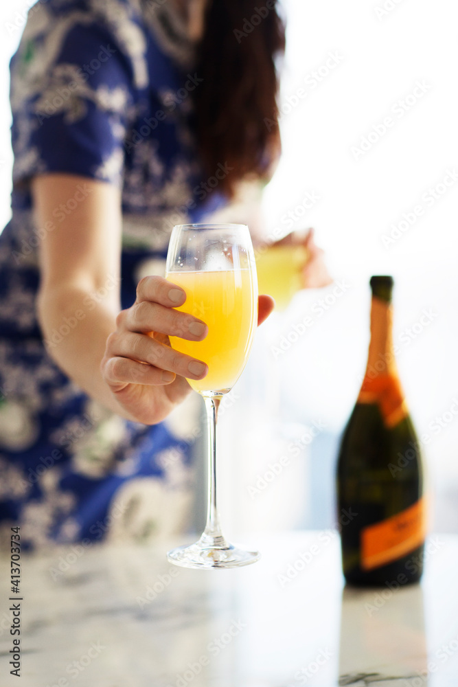 Midsection of woman holding glass of juice while standing at home Midsection of woman holding glass of juice while standing at home