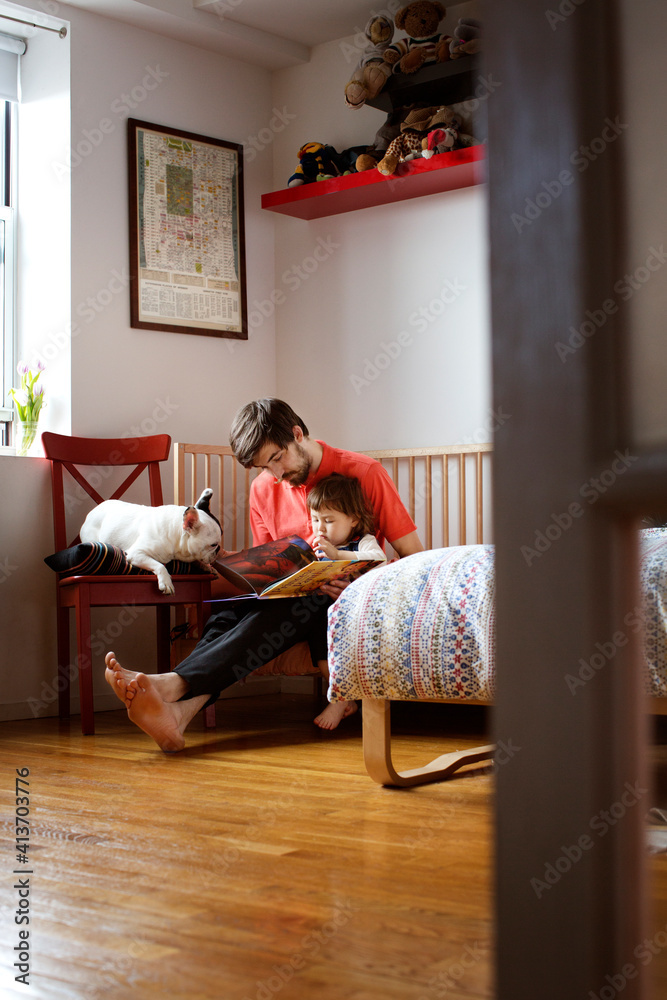 Father and daughter reading book while sitting with dog at home Father and daughter reading book while sitting with dog at home