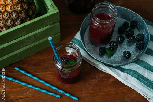 High angle view of blackberries with drink on table