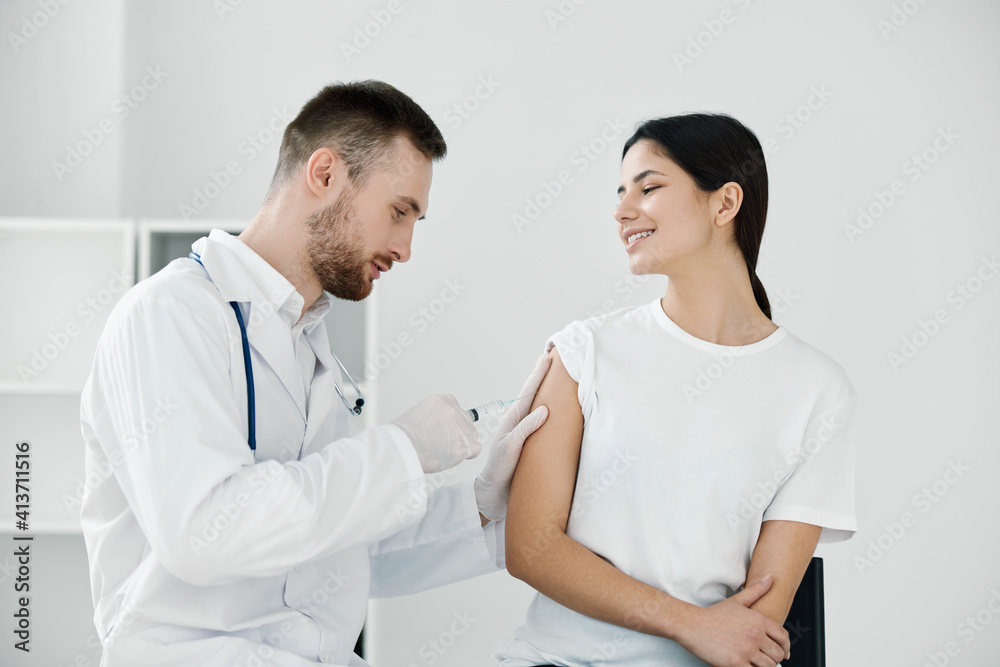 the doctor gives an injection of coronavirus infection into the patient's shoulder vaccination the doctor gives an injection of coronavirus infection into the patient's shoulder vaccination