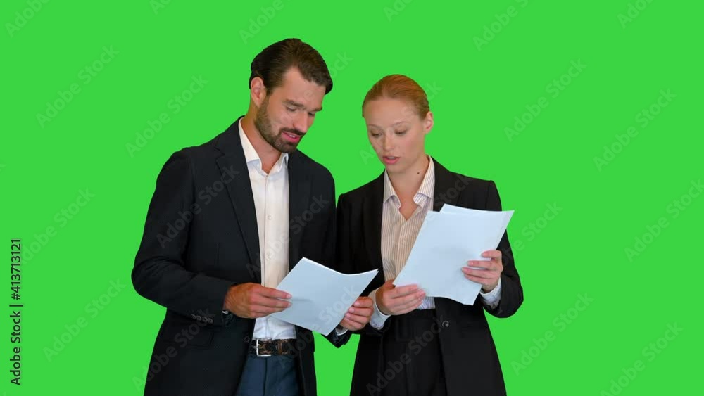 Two young business people talking about documents on a Green Screen, Chroma Key. Two young business people talking about documents on a Green Screen, Chroma Key.