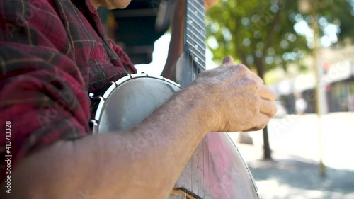 Close up of banjo player on sidewalk photo