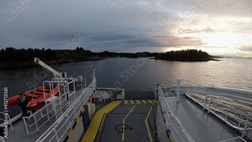 Timelapse of Electric Norwegian car ferry sailing narrow waters at dawn sunset photo