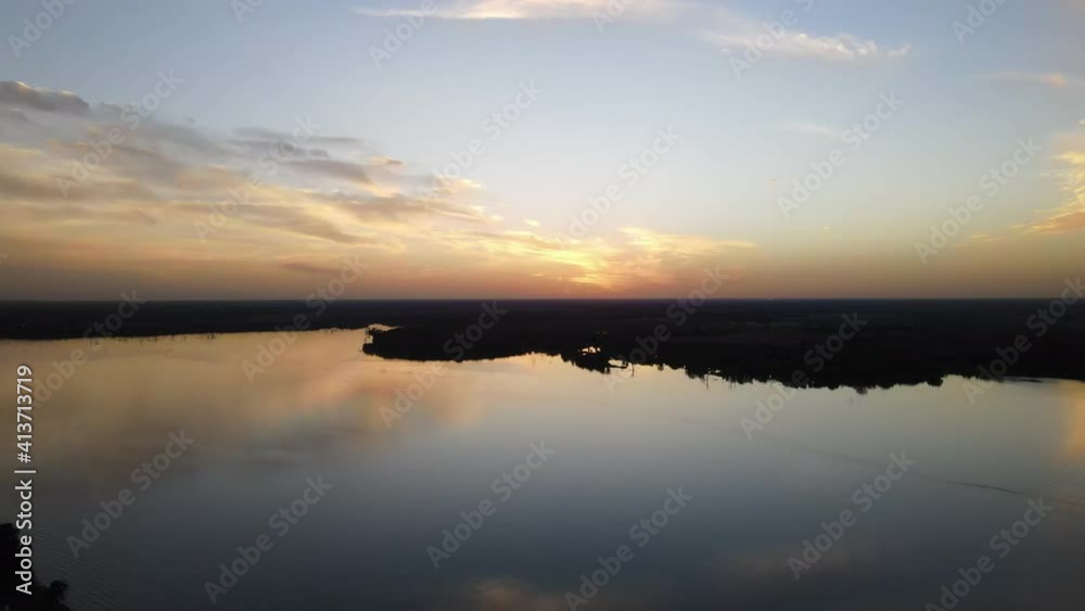 Sunset over coastal beaches of an island and the sky reflected on the calm waters below. Sunset over coastal beaches of an island and the sky reflected on the calm waters below.