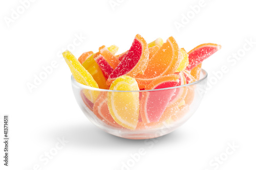 sugar jelly candies in a glass bowl in the form of fruit slices isolated on a white background