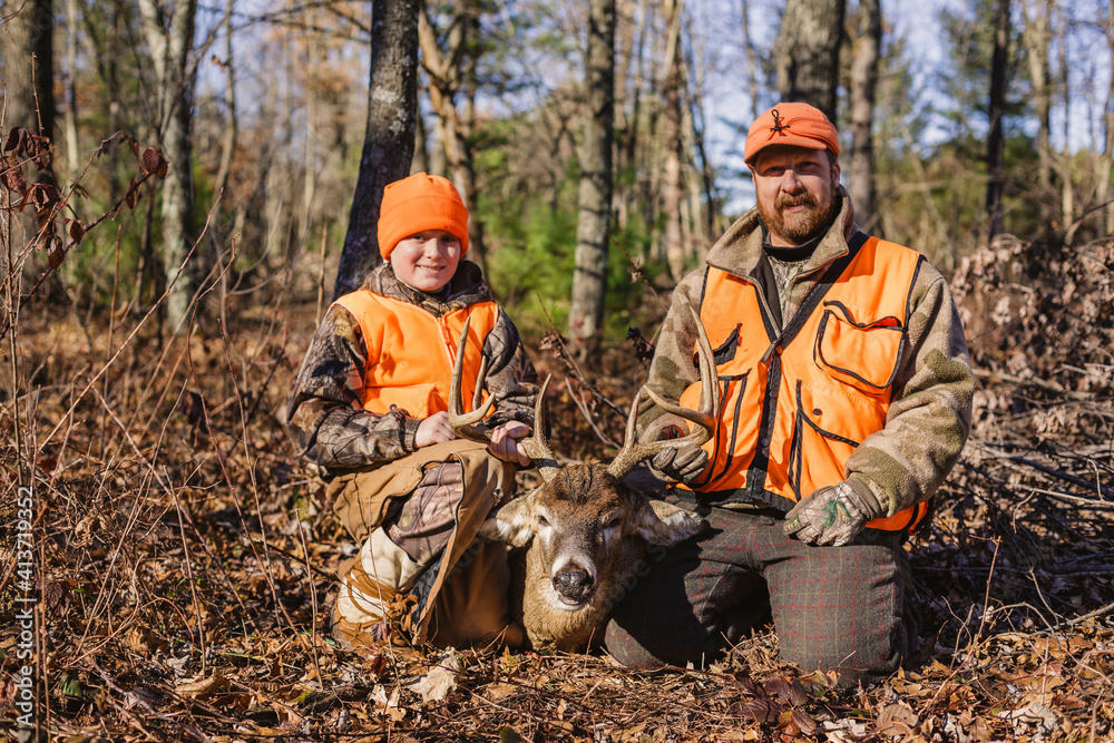 Portrait of father and daughter with dead deer on field during hunting Portrait of father and daughter with dead deer on field during hunting