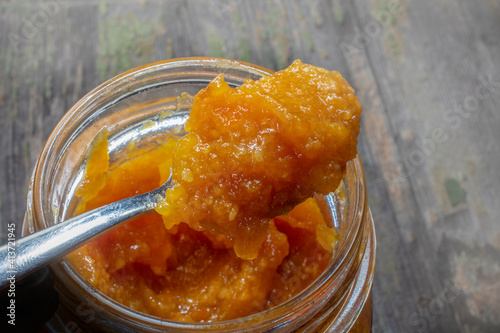 Spoon of Fresh Domestic Orange Marmalade Over Opened Jar