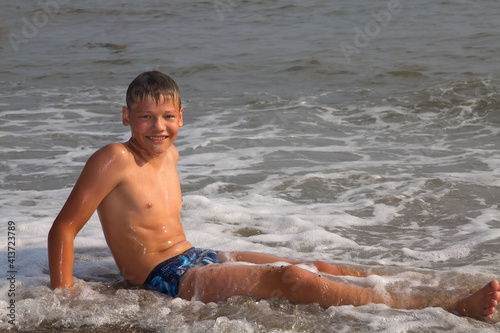 European boy, teenager, swimming in the sea.