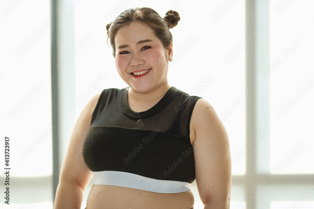Young and lovely cute Asian fat woman in sport wear pose to camera with a happy and positive gesture with self-confidence and self-esteem