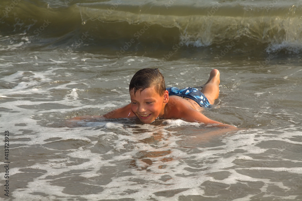 European boy, teenager, swimming in the sea.