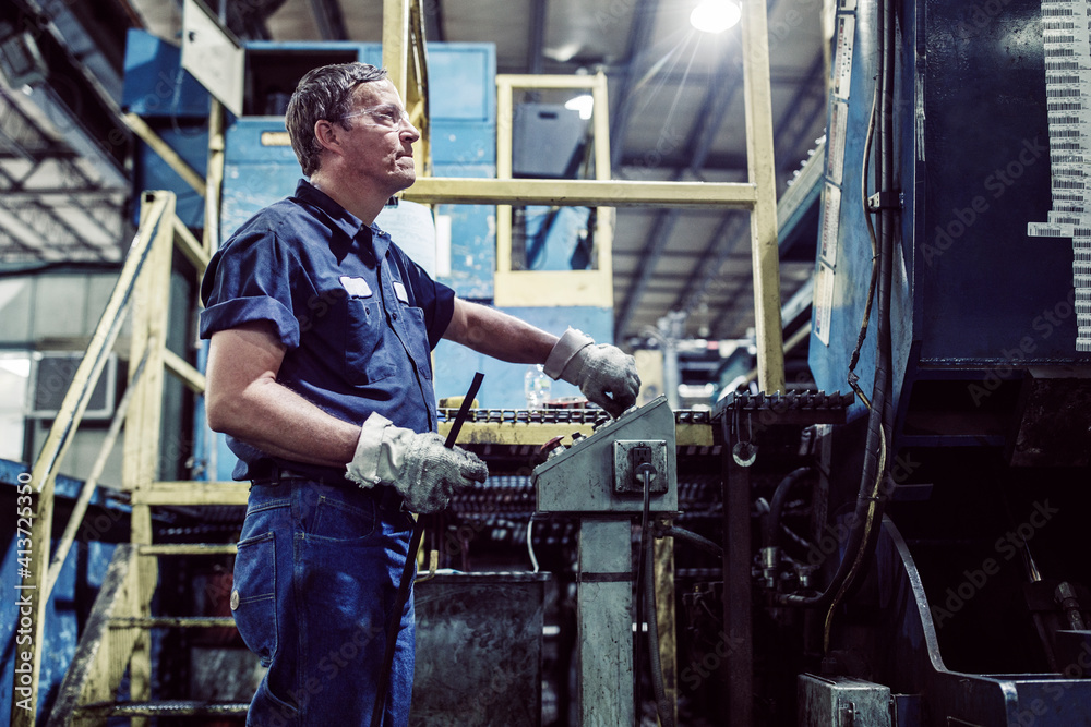 Worker using control machine while working in steel industry Worker using control machine while working in steel industry