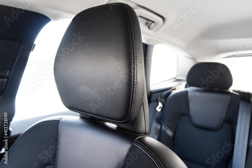 Modern luxury car black leather interior. Part of perforated leather car seat details with white stitching. Interior of prestige car. Comfortable perforated leather seats. Perforated leather. © Aleksei