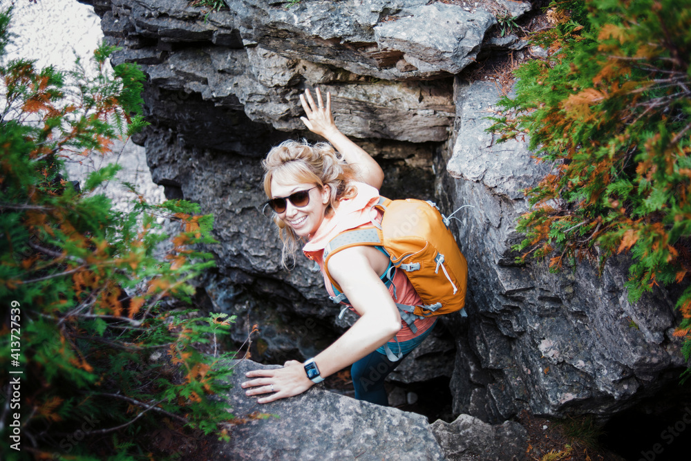 High angle portrait of female hiker with backpack amidst rocks at Bruce Peninsula National Park High angle portrait of female hiker with backpack amidst rocks at Bruce Peninsula National Park