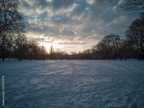 View of a snowy park landscape with interesting colored sky and sunset in Leipzig,Germany,EU