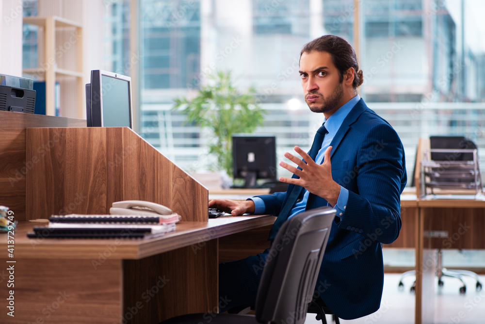 Young male employee working in the office Young male employee working in the office