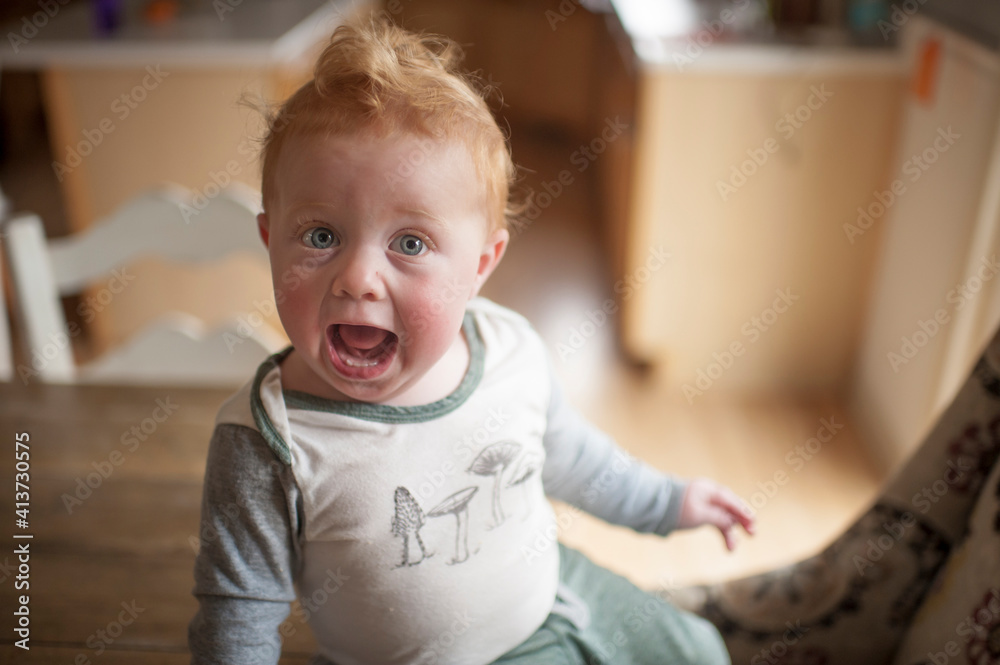 High angle portrait of baby boy with mouth open sitting on table at home High angle portrait of baby boy with mouth open sitting on table at home