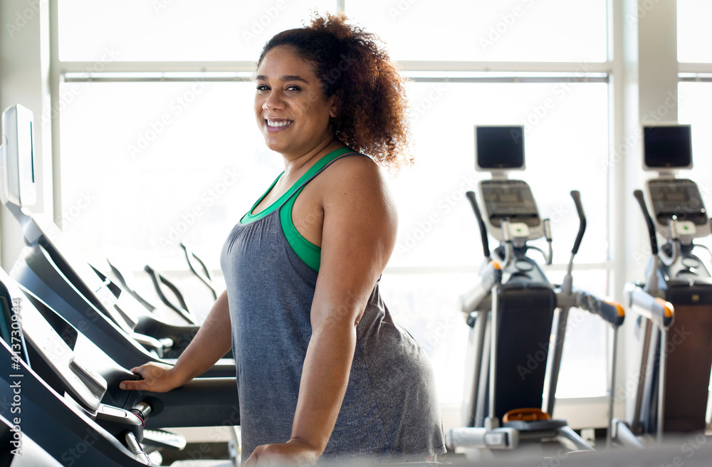 Portrait of curvy woman on treadmill in gym Portrait of curvy woman on treadmill in gym