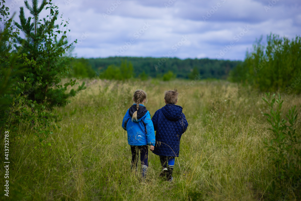 summer forest, field, nature,, two children in blue jackets stand in a field, field in June summer forest, field, nature,, two children in blue jackets stand in a field, field in June