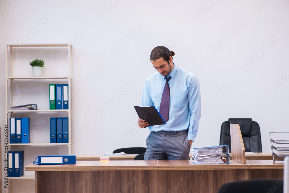 Young male employee working in the office Young male employee working in the office