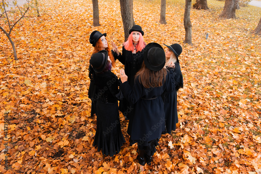 Coven of witches, a group of friends as witches on Halloween perform a ...