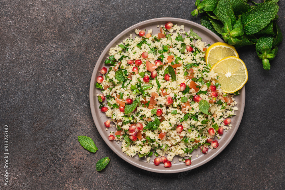 Tabbouleh salad with couscous, tomato, mint, parsley and pomegranate seeds. Traditional Middle Eastern cuisine Tabbouleh salad with couscous, tomato, mint, parsley and pomegranate seeds. Traditional Middle Eastern cuisine