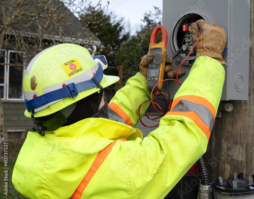 Female electrician using her meter