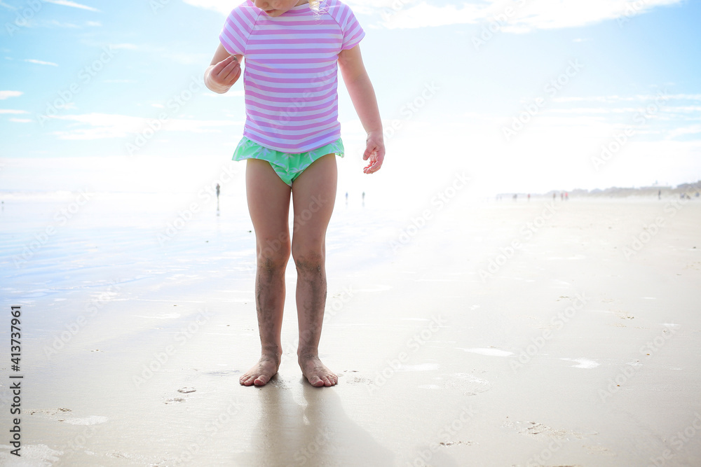 Low section of girl standing on sand against sky Low section of girl standing on sand against sky