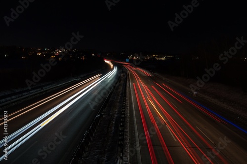 Befahrene Autobahn mit Langzeitbelichtung aufgenommen in einer dunklen, kalten Nacht mitten in Deutschland.