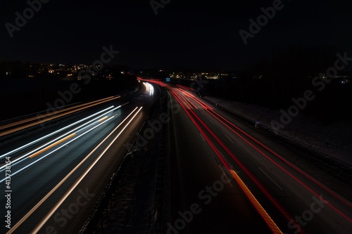 Befahrene Autobahn mit Langzeitbelichtung aufgenommen in einer dunklen, kalten Nacht mitten in Deutschland.