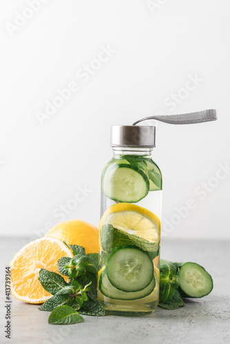 Lemon, cucumber and mint water in glass bottles. Sassy water for detox or dieting on white background. Healthy eating, weight loss, lifestyle concep