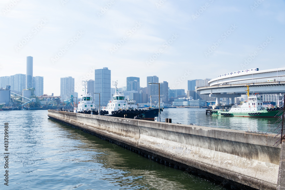 青空を背景に芝浦ふ頭の岸壁に停泊する船とループ橋を走るモノレール