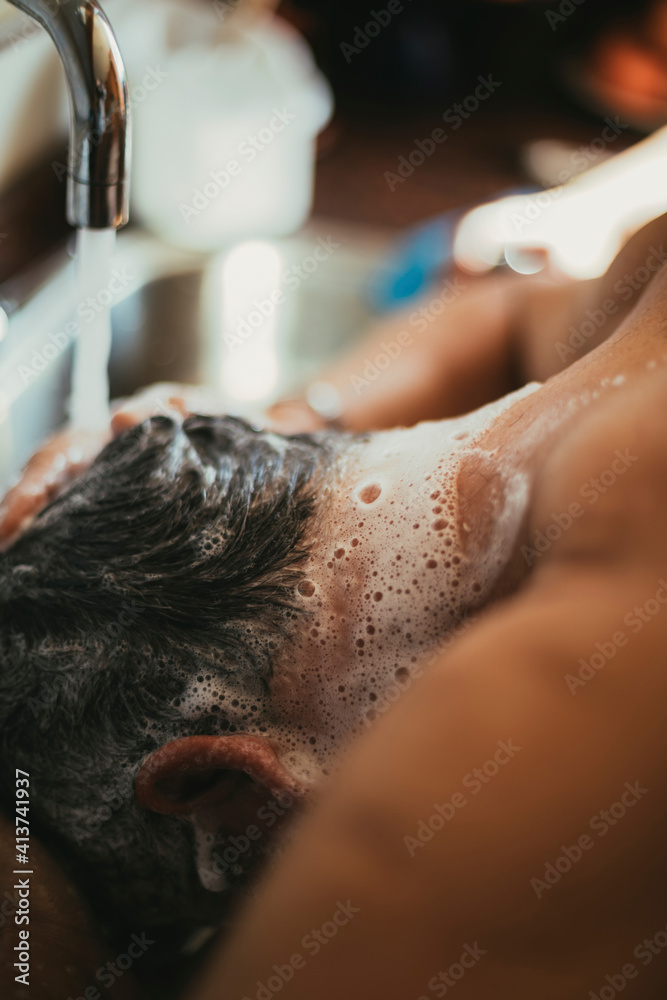 Close-up of man washing hair at barber shop Close-up of man washing hair at barber shop