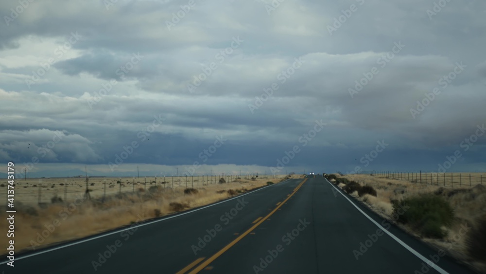 Driving auto, road trip in California, USA, view from car. Hitchhiking traveling in United States. Highway, mountains and cloudy dramatic sky before rain storm. American scenic byway. Passenger POV.