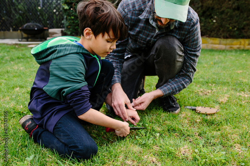 Father assisting son in cutting grass at Newbury Park photo