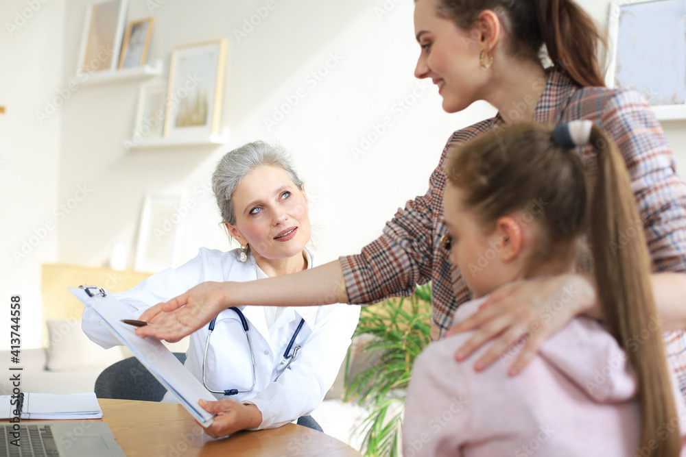 Obraz premium Mother and child in the doctor office meeting the pediatrician, they are sitting at desk in hospital.