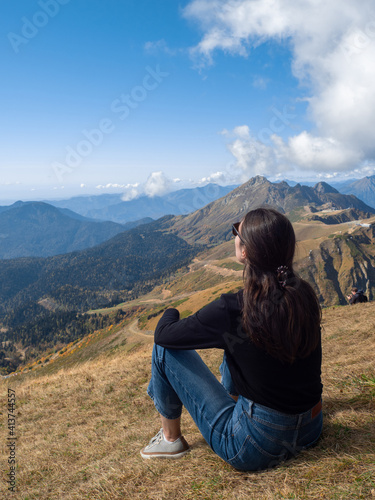 Young female tourist sitting and enjoying the beautiful nature. Hiking in national parks,