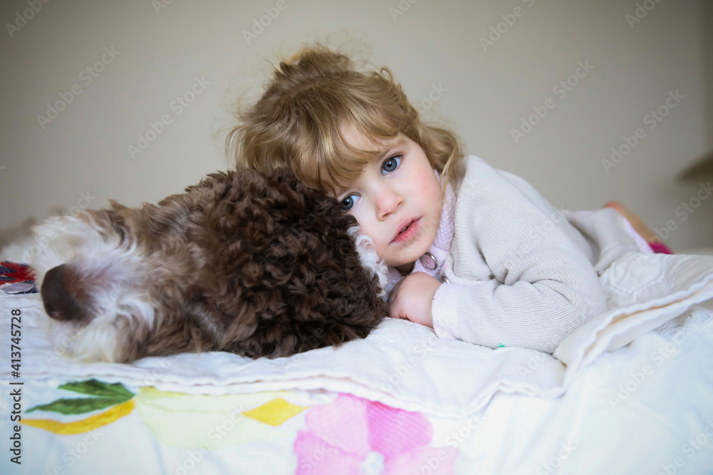 Portrait of girl relaxing with dog on bed at home Portrait of girl relaxing with dog on bed at home