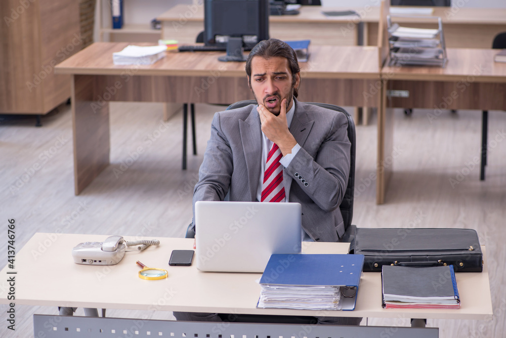 Young male employee working in the office Young male employee working in the office