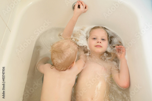 Portrait of sister with brother bathing in bathtub at home