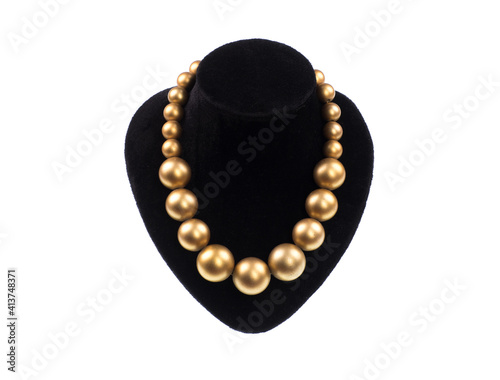 necklace with golden pearls on a mannequin isolated on white background