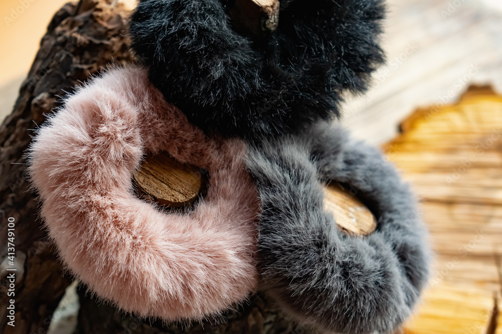 Fashionable and stylish fur elastic bands for hair and hairstyles. Multi-colored artificial and natural cannons on a natural wooden background Fashionable and stylish fur elastic bands for hair and hairstyles. Multi-colored artificial and natural cannons on a natural wooden background