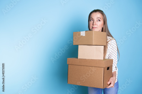 Accept a parcel, happy young woman holding a stack of cardboard boxes, © Alexander