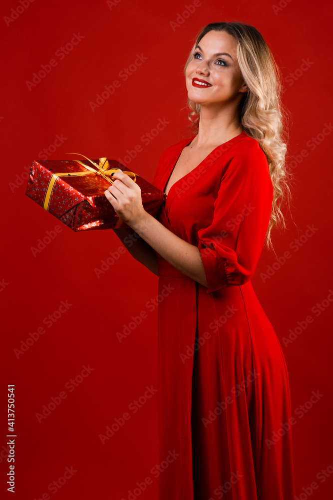 happy and beautiful blonde in a red dress received a welcome gift. happy and beautiful blonde in a red dress received a welcome gift.