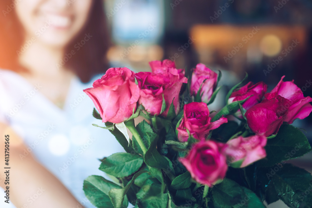 Woman happy hold pink roses recieve from someone in love on Valentine's day.