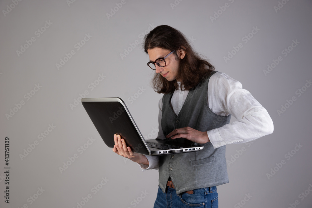 Training and new technologies, online courses, e-learning. A young man with long hair and glasses. Training and new technologies, online courses, e-learning. A young man with long hair and glasses.