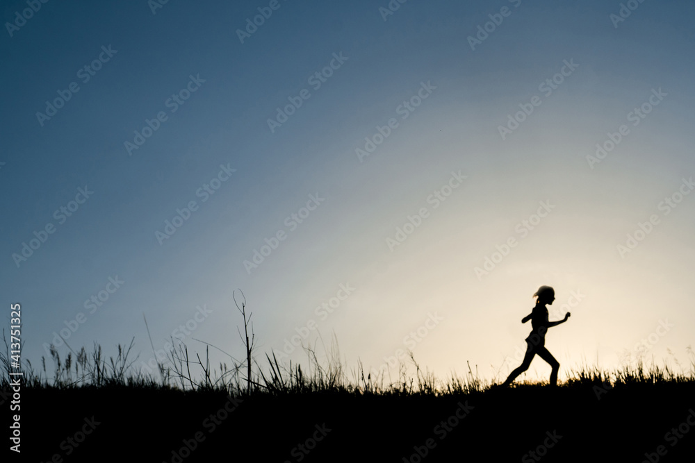 Silhouette girl running on grassy field against clear sky during dusk Silhouette girl running on grassy field against clear sky during dusk